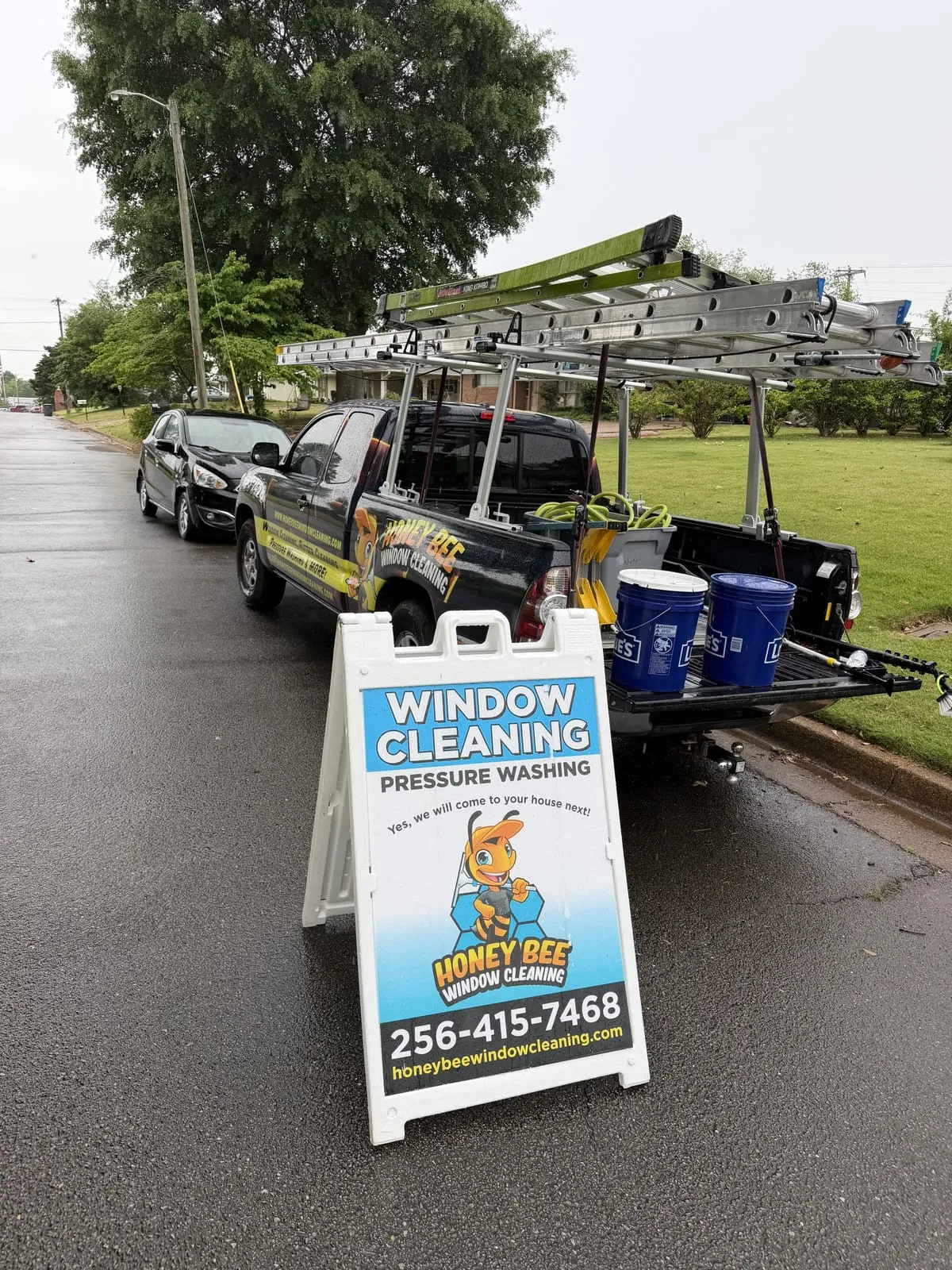 HoneyBee wrapped work truck with ladder rack and window cleaning yard sign